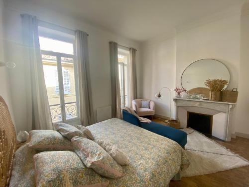 a bedroom with a bed and a fireplace and a mirror at Appartement Haussmannien rue piétonne Opéra in Marseille