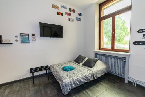 a bedroom with a bed and a tv on a wall at Private & Comfortable Apartments in Puttelange-aux-Lacs