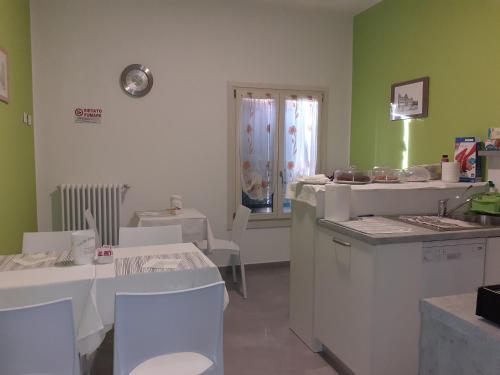 una cucina con elettrodomestici bianchi, tavolo e sedie di Royal Room & Breakfast a Modena