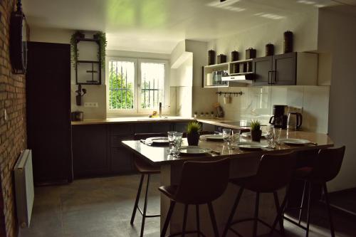 a kitchen with a table with chairs and a counter top at Private & Comfortable Apartments in Puttelange-aux-Lacs