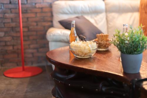 a table with a bottle of beer on a couch at Private & Comfortable Apartments in Puttelange-aux-Lacs