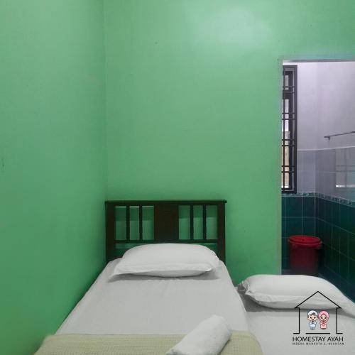 Кровать или кровати в номере Homestay Ayah (IM2)