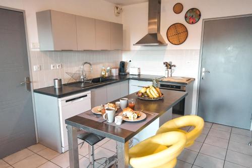 - une cuisine avec une table et un bol de fruits dans l'établissement Caz Patio, T2 - 4 étoiles, front de mer, à Saint-Pierre