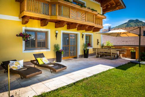 a patio with a deck and a table and benches at Appartement Reitlhof, Bio Berg Bauernhof in Krispl