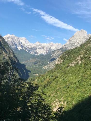 a view of a mountain valley with snow covered mountains at Bujtina Arlindi in Valbonë