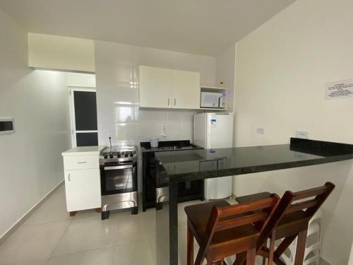 a kitchen with white cabinets and a black counter top at Condominio Boa Vista in Pontal do Paraná