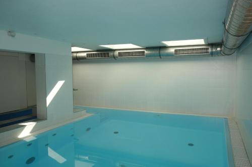 a swimming pool with blue water in a room at Nordland Appartements - Wohnung Amrum in Wyk auf Föhr