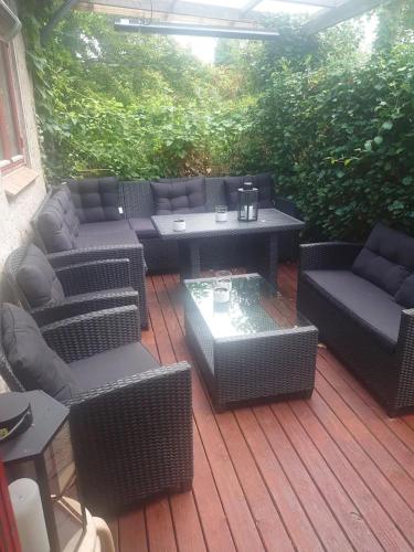 een patio met rieten meubels en een tafel en stoelen bij Byhus Vejle in Vejle