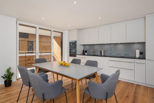eine Küche und ein Esszimmer mit einem Tisch und Stühlen in der Unterkunft Moderne Neubauwohnung in Wilderswil in Wilderswil