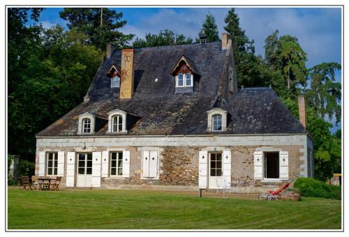 une ancienne maison en pierre avec un toit en gambrel dans l'établissement Magnifique château au bord de la Mayenne 18 couchages, 