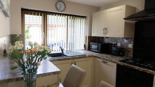 a kitchen with a vase of flowers on a counter at Plas Bach in Swansea