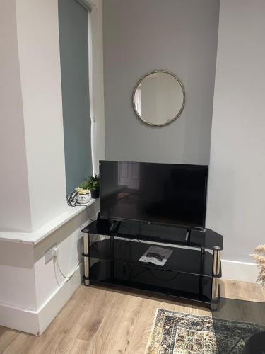 a living room with a tv and a mirror at 2 Bedroom House next to Slade Green Station in Slades Green