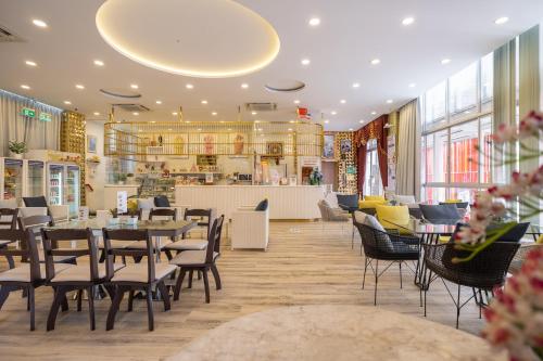 a restaurant with tables and chairs and a counter at Bangkok Rama Hotel in Bangkok