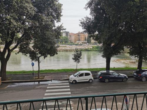 dos coches estacionados en un estacionamiento junto a un río en La Luna sull'Adige, en Verona