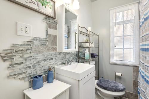 a bathroom with a sink and a toilet and a mirror at Stylish, Tranquil & Comfy ~ Queen Beds ~ Pkg in Detroit