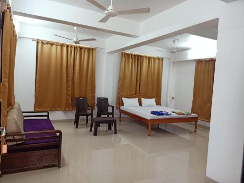 a bedroom with a bed and a couch and chairs at KIHIM HOLIDAY HOME in Kīhīm