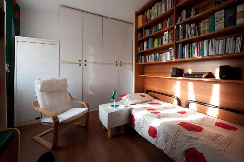 1 dormitorio con cama, silla y estante para libros en BBnaon, en Pordenone