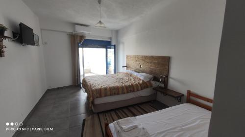 a hotel room with two beds and a television at Carpe diem in Galatas