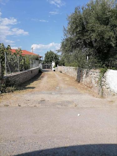 a dirt road with a stone wall and a tree at Studio P & P Polylimnio Waterfalls in Dhouvraíika