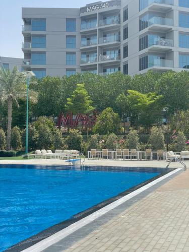 ein Schwimmbad vor einem hohen Gebäude in der Unterkunft MAG 565, Boulevard, Dubai South, Dubai in Dubai