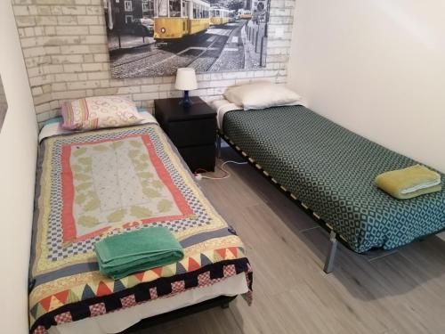 a room with two beds and a picture of a train at Paradise Space in Lisbon