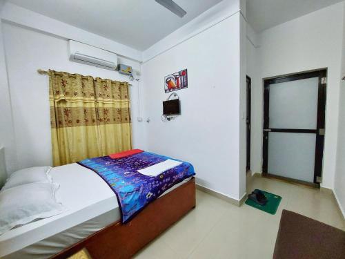 a small bedroom with a bed and a window at Lumbini Garden Lodge in Lumbini