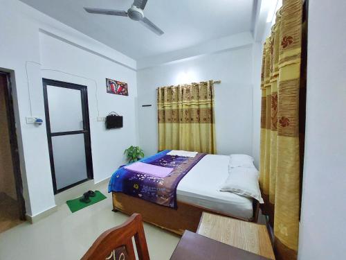 a small bedroom with a bed and a mirror at Lumbini Garden Lodge in Lumbini
