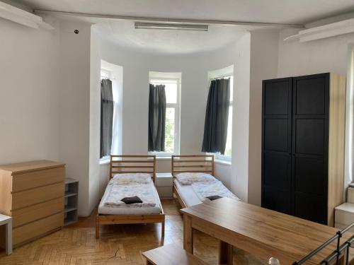 ウィーンにあるアパートメンツ ハイネのベッド2台と木製テーブルが備わる客室です。