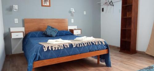 a bedroom with a blue bed with towels on it at Complejo SABEJO in San Antonio de Areco