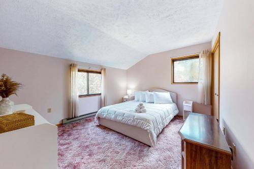 a bedroom with a bed and a desk and two windows at House in the Woods in Albrightsville