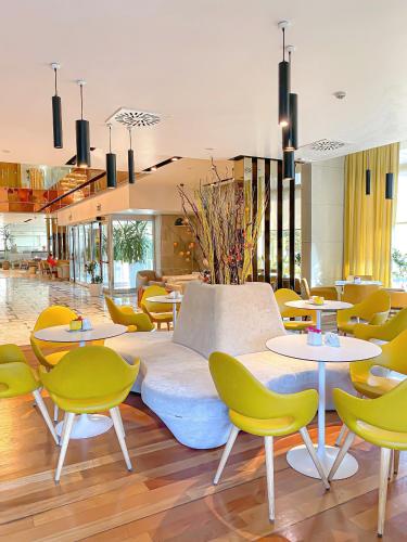 a lobby with tables and chairs and a couch at Tirana International Hotel & Conference Center in Tirana