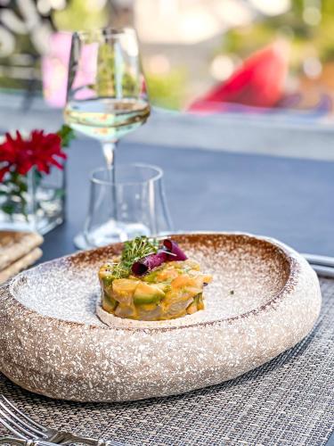 a plate of food on a table with a glass of wine at Tirana International Hotel & Conference Center in Tirana