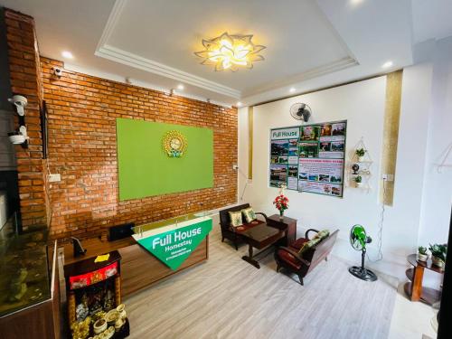 ein Wohnzimmer mit einer großen Ziegelwand in der Unterkunft Full House Homestay in Hue