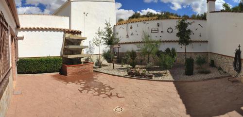 un patio con un edificio con una escalera y un jardín en Vivienda Turística Rural, en Granada