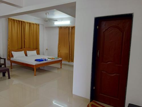 a bedroom with a bed and a wooden door at KIHIM HOLIDAY HOME in Kīhīm