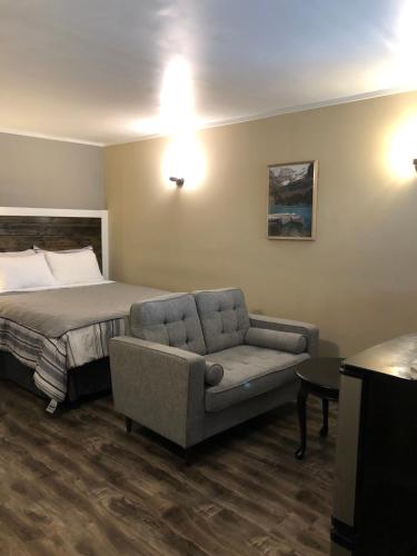 a hotel room with a bed and a chair at Greenside Motel in Saint Andrews