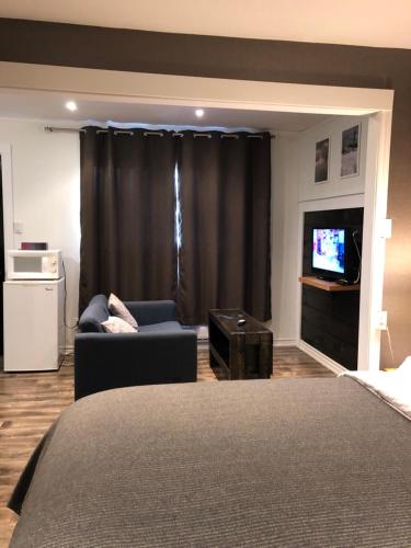 a living room with a bed and a tv and a couch at Greenside Motel in Saint Andrews