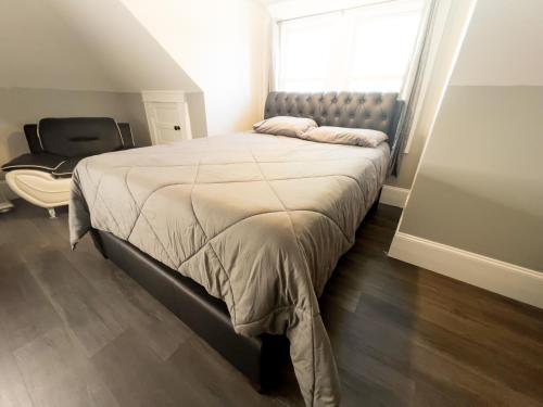 a bedroom with a large bed and a chair at The Blue Chip Villa in Niagara Falls