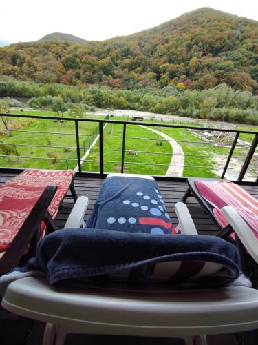 balcón con sillas, mesa y vistas al río en Villa Opir, en Skole