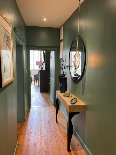 a hallway with a table and a mirror on the wall at Suite avec Spa Quartier Cathédrale in Autun