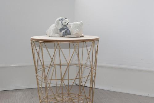 un oso de peluche sentado en la parte superior de una mesa redonda en Vion Apartment - King Suites en Aberdeen