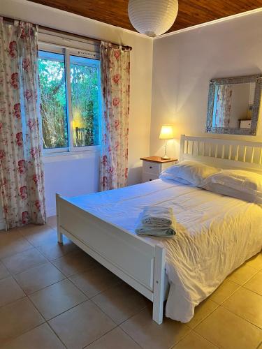 une chambre avec un lit blanc et une fenêtre dans l'établissement Le Bourg, à Concots