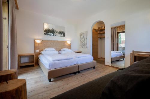 a large bedroom with two beds and a mirror at Rooms Kronblick in San Lorenzo di Sebato