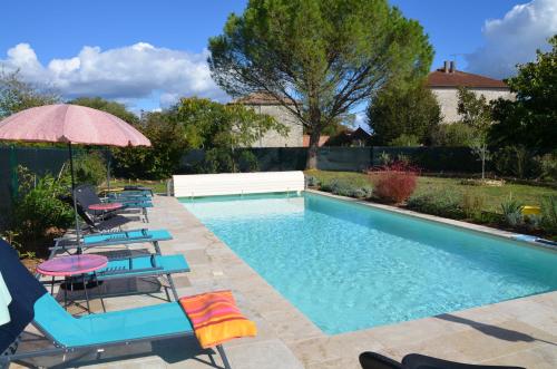 einen Pool mit Stühlen und einem Sonnenschirm in der Unterkunft Le Gîte de La Maison des Chats in Saint-Amans-du-Pech