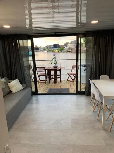 sala de estar con sofá y mesa en Unique new houseboat moored 4, en Zwartsluis