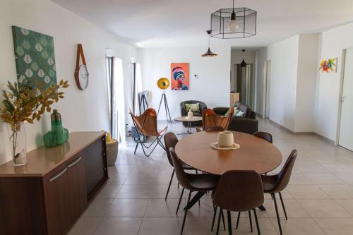 une salle à manger et un salon avec une table et des chaises dans l'établissement VILLA avec PISCINE chauffée trois chambres, à Saint-Sulpice-de-Royan