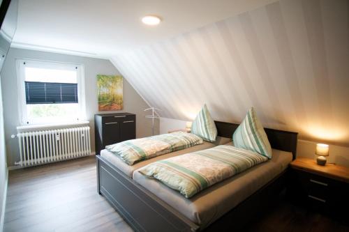 - un lit avec 2 oreillers dans l'établissement Ferienwohnung Ravensberg Dachgeschoss, à Bad Sachsa