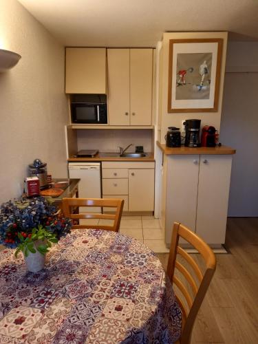 une cuisine avec une table et une cuisine avec une table et des chaises dans l'établissement Studio cosy Ty Avel avec parking , balcon & Wifi, à Quiberon