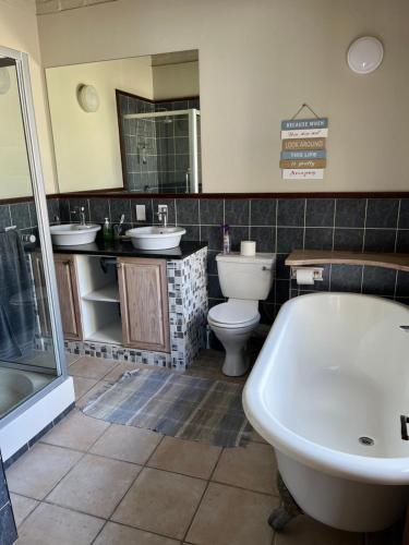 a bathroom with two sinks and a tub and two toilets at Coastal Haven in Scarborough