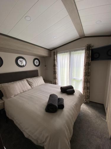 a bedroom with a large bed with two towels on it at Riverwood Lodge in Newquay Bay Resort